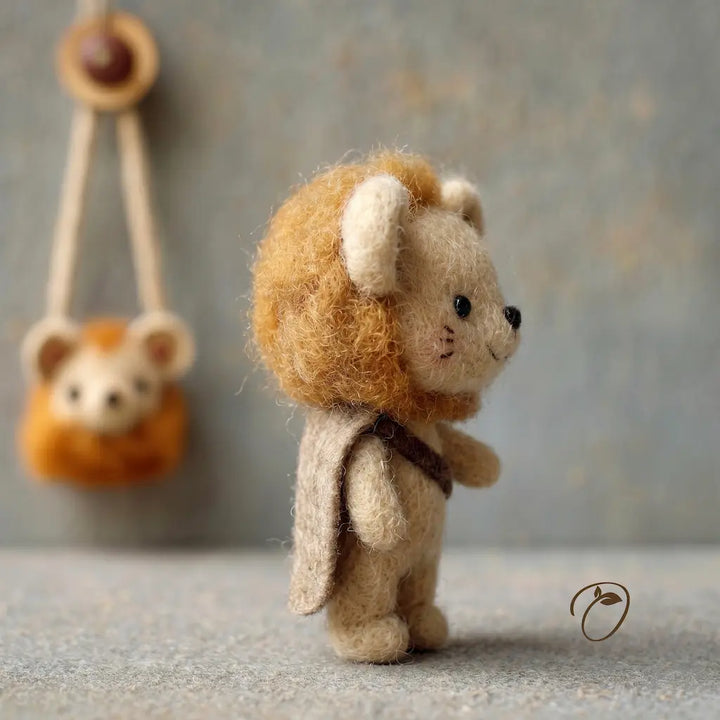 Small teddy bear with lion mane and costume standing on a textured surface with a blurred background