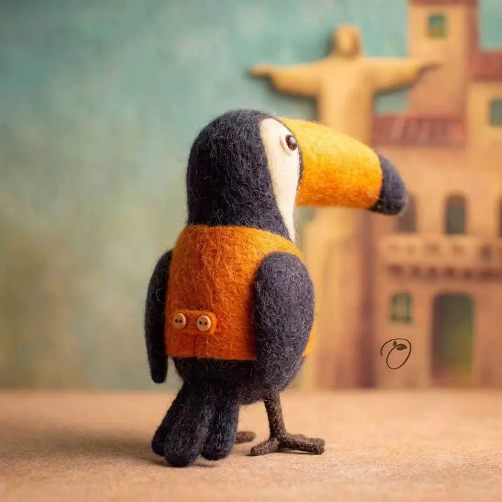 Toy toucan with a backpack in front of a blurred building