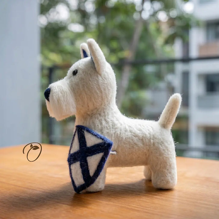White dog-shaped plush toy with a blue and white flag on a wooden surface