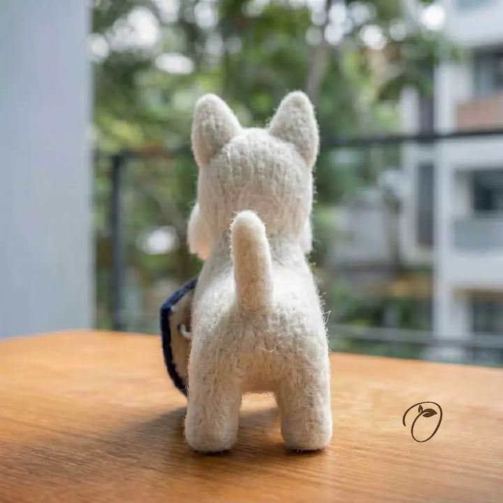 White plush dog toy on a wooden surface with a blurred outdoor background
