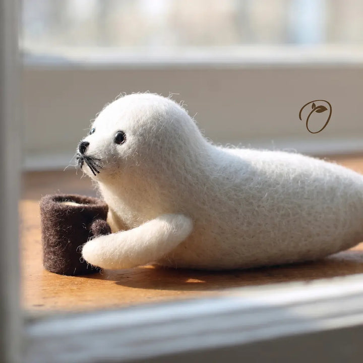 White seal toy sitting on a wooden surface with a blurred background