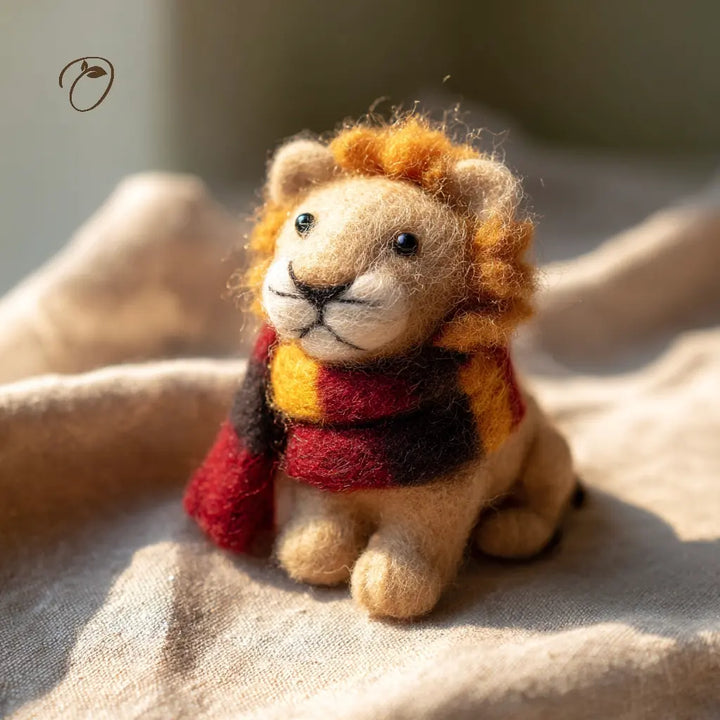 Small lion figurine wearing a scarf on a textured surface