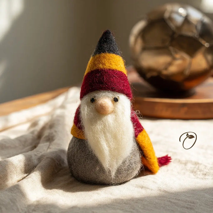 Felted gnome with a colorful hat on a textured surface