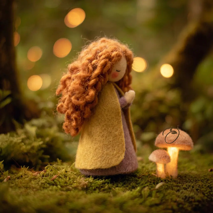 Felted doll with long hair and a yellow coat standing in a forest with glowing lights and mushrooms.
