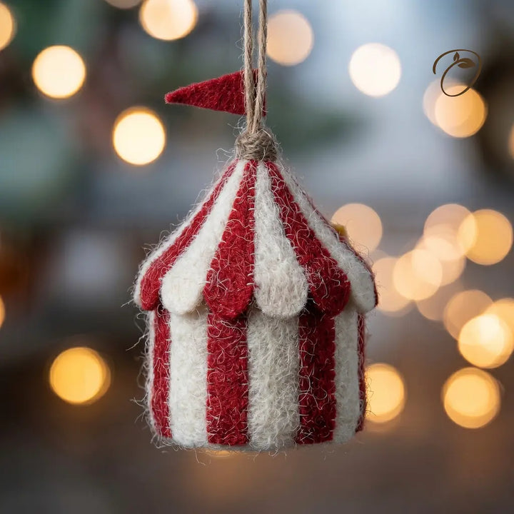 Decorative striped tent ornament against a blurred festive background with lights.