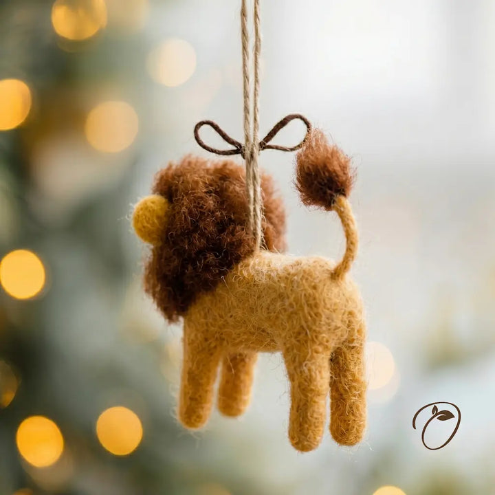 Felt lion ornament hanging against a blurred bokeh background