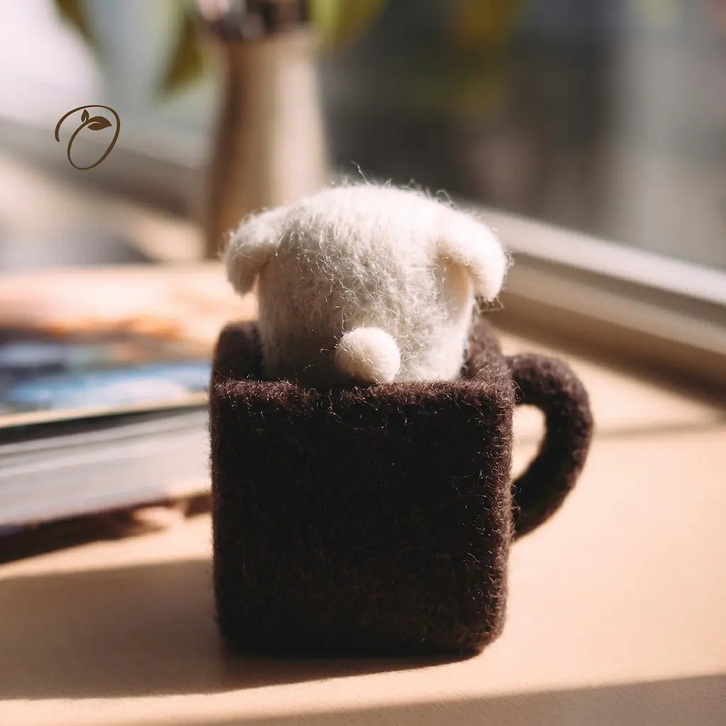 Small figurine in a brown mug on a wooden surface with a blurred background