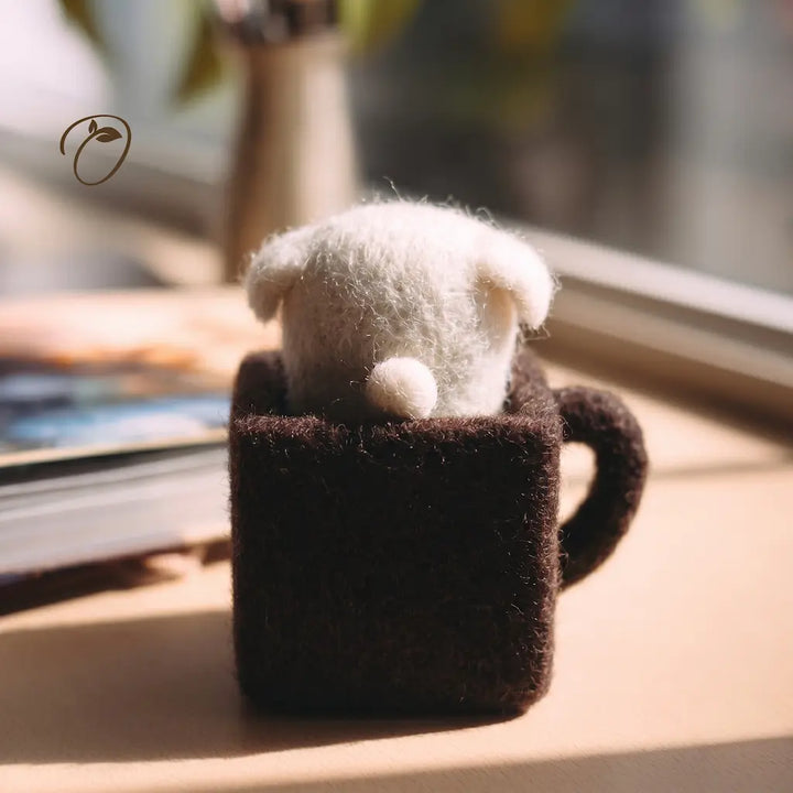Small figurine in a brown mug on a wooden surface with a blurred background
