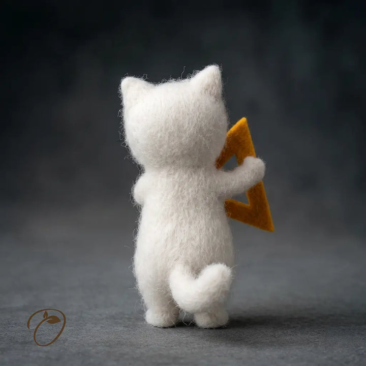 White felted cat figurine holding a yellow triangle on a dark background