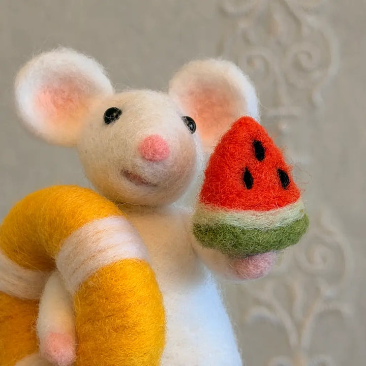 Mouse figurine holding a watermelon slice against a neutral background