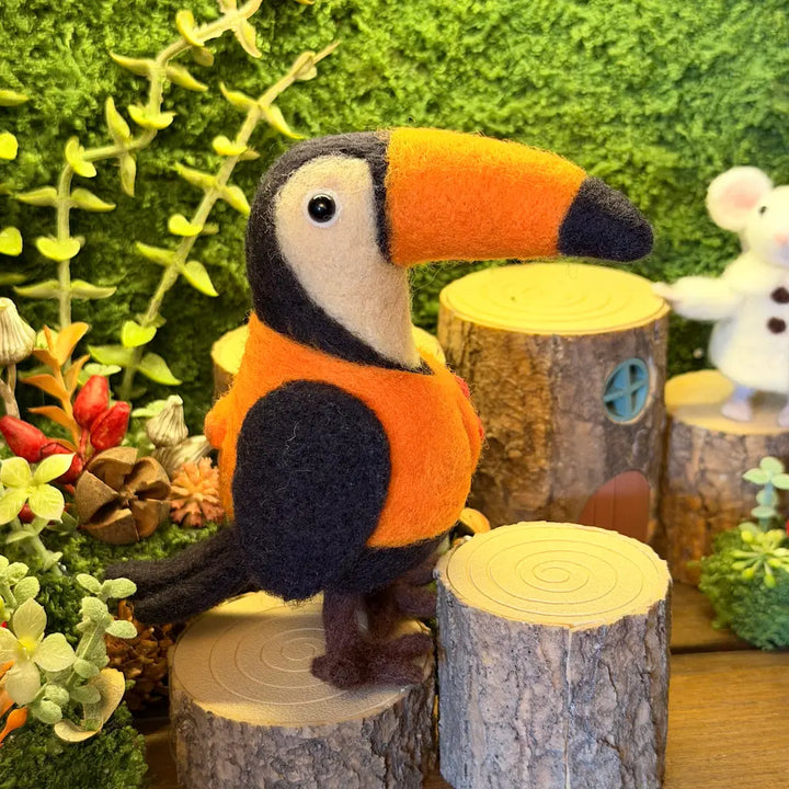 Toucan figurine on a wooden stump with a forest background