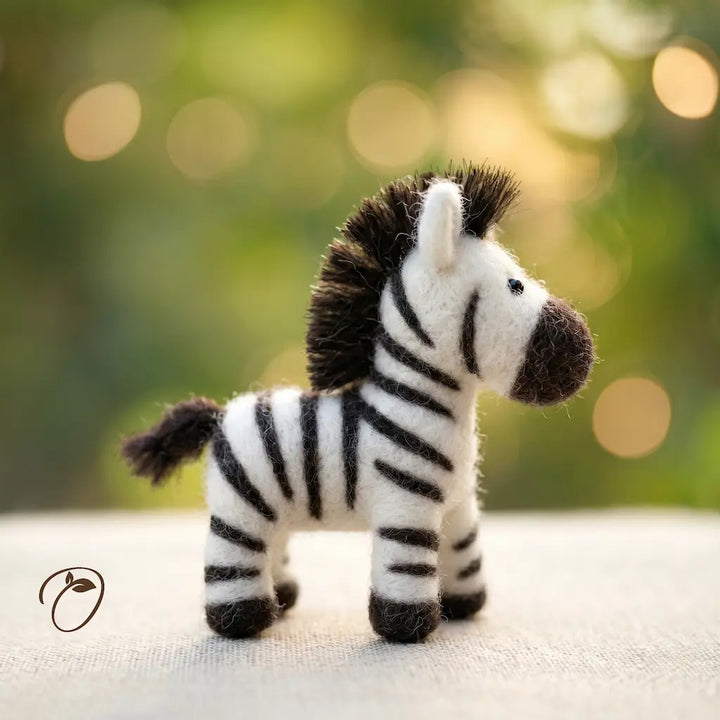 Toy zebra on a textured surface with a blurred natural background