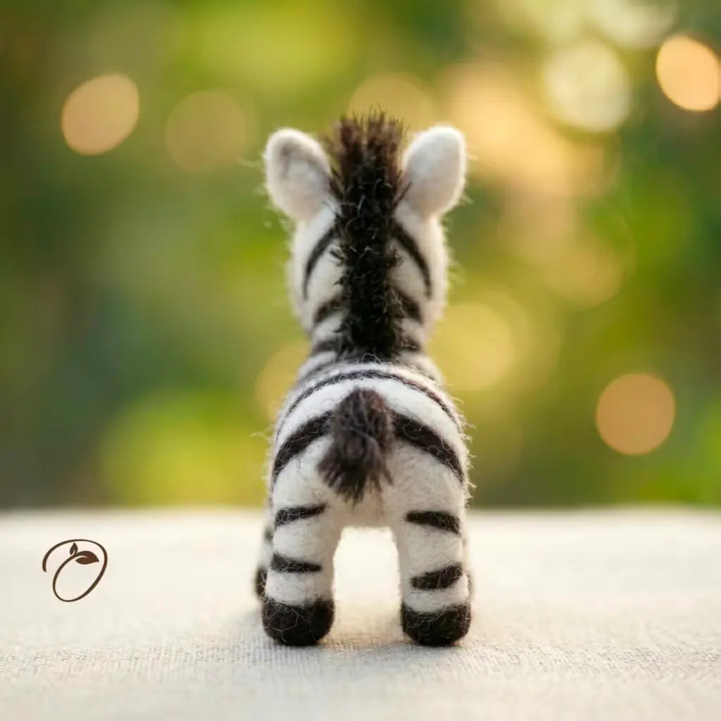 Toy zebra from behind with a blurred green background