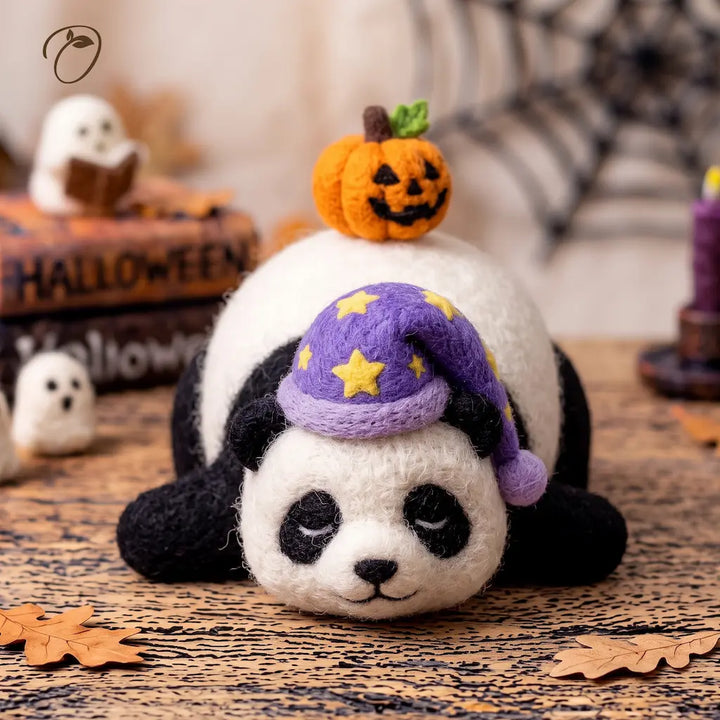 Front view of a sleeping felt panda with closed eyes, a purple star-patterned nightcap and a pumpkin on its back