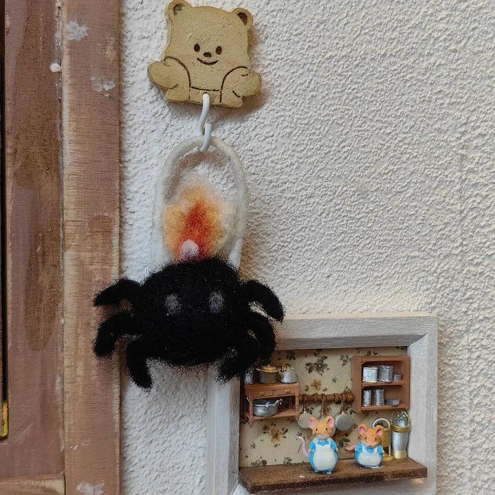 Black spider lantern felt ornament hanging in a miniature cozy room display