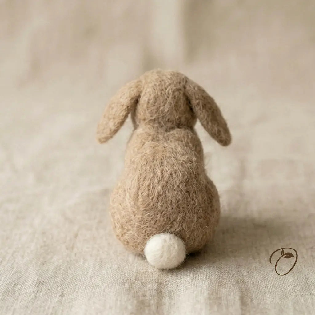 Textured brown rabbit toy on a beige fabric background