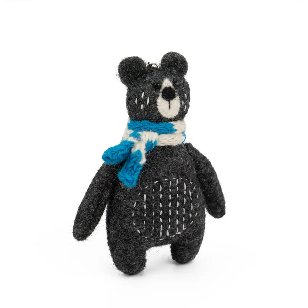 Stuffed bear toy with a blue scarf on a white background