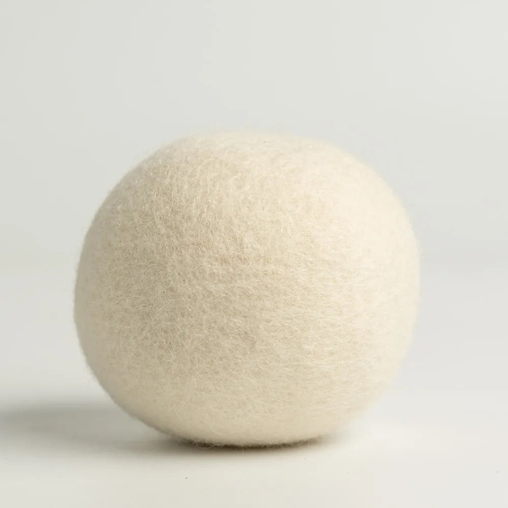 Close-up shot of a single 100% organic wool dryer ball, showing its dense, hand-felted texture.