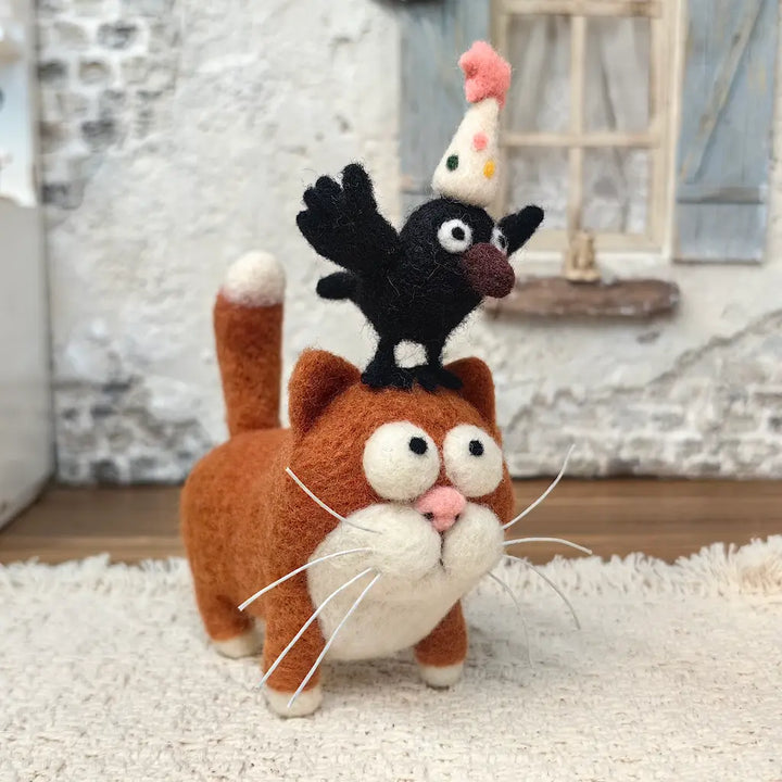 Handmade Party Crow and Cat wool felt figurine featuring a wide-eyed ginger cat with a black crow wearing a colorful party hat perched on its head.