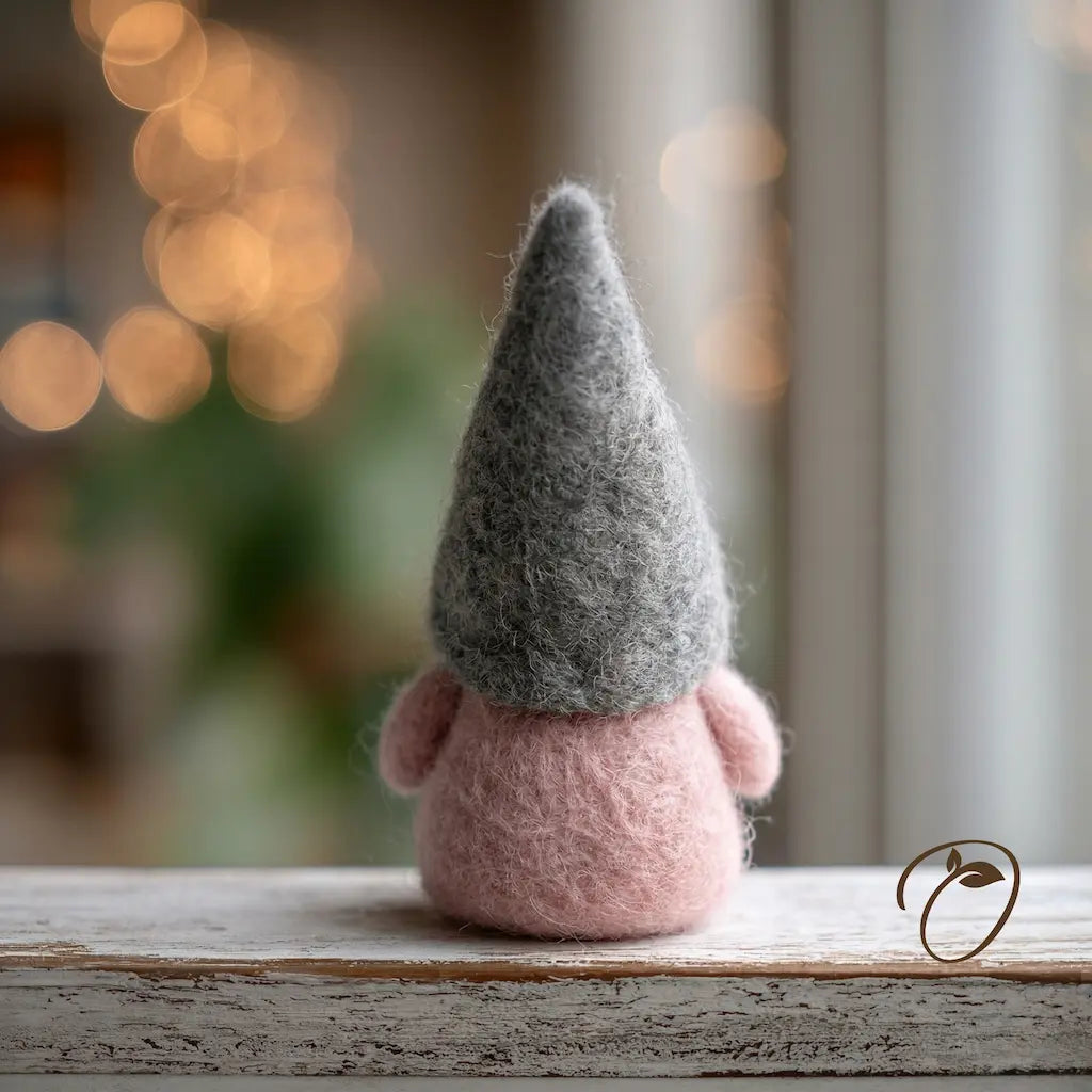 Small gnome figurine with a gray hat and pink body on a wooden surface with a blurred background