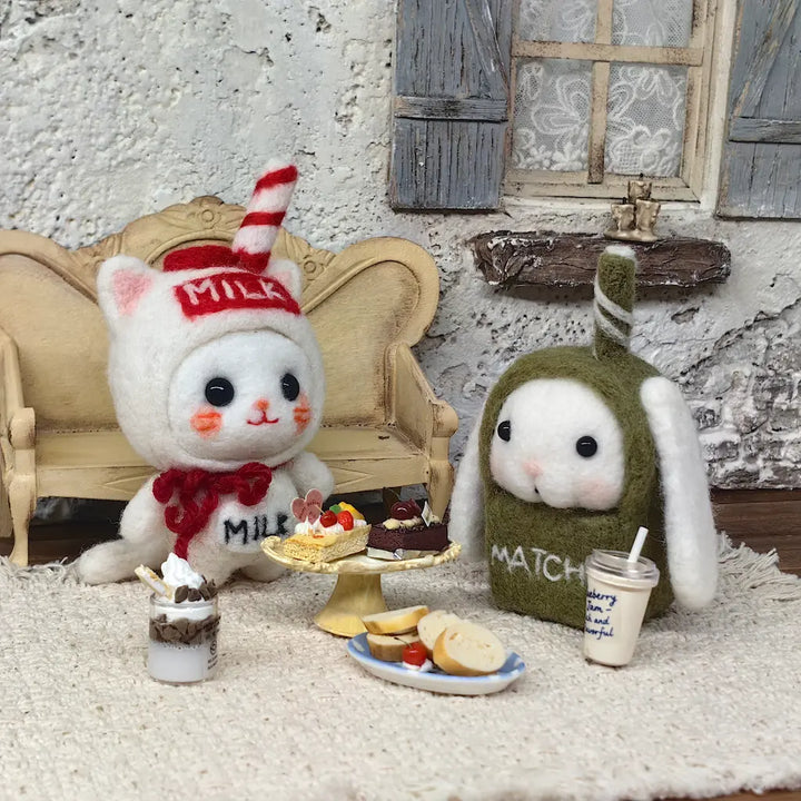Milk Carton Cat and Matcha Bunny felt figurines with miniature cakes and drinks in a cozy cafe scene