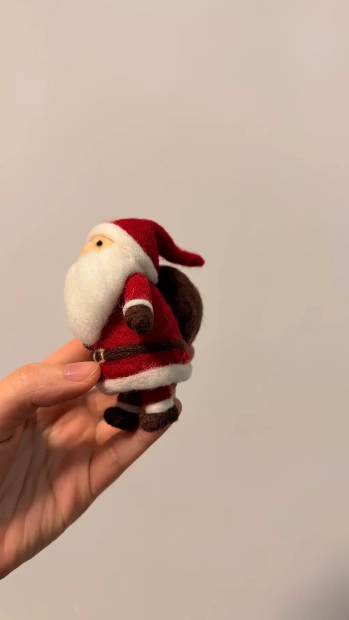 Small Walking Santa wool felt figurine held in hand for scale