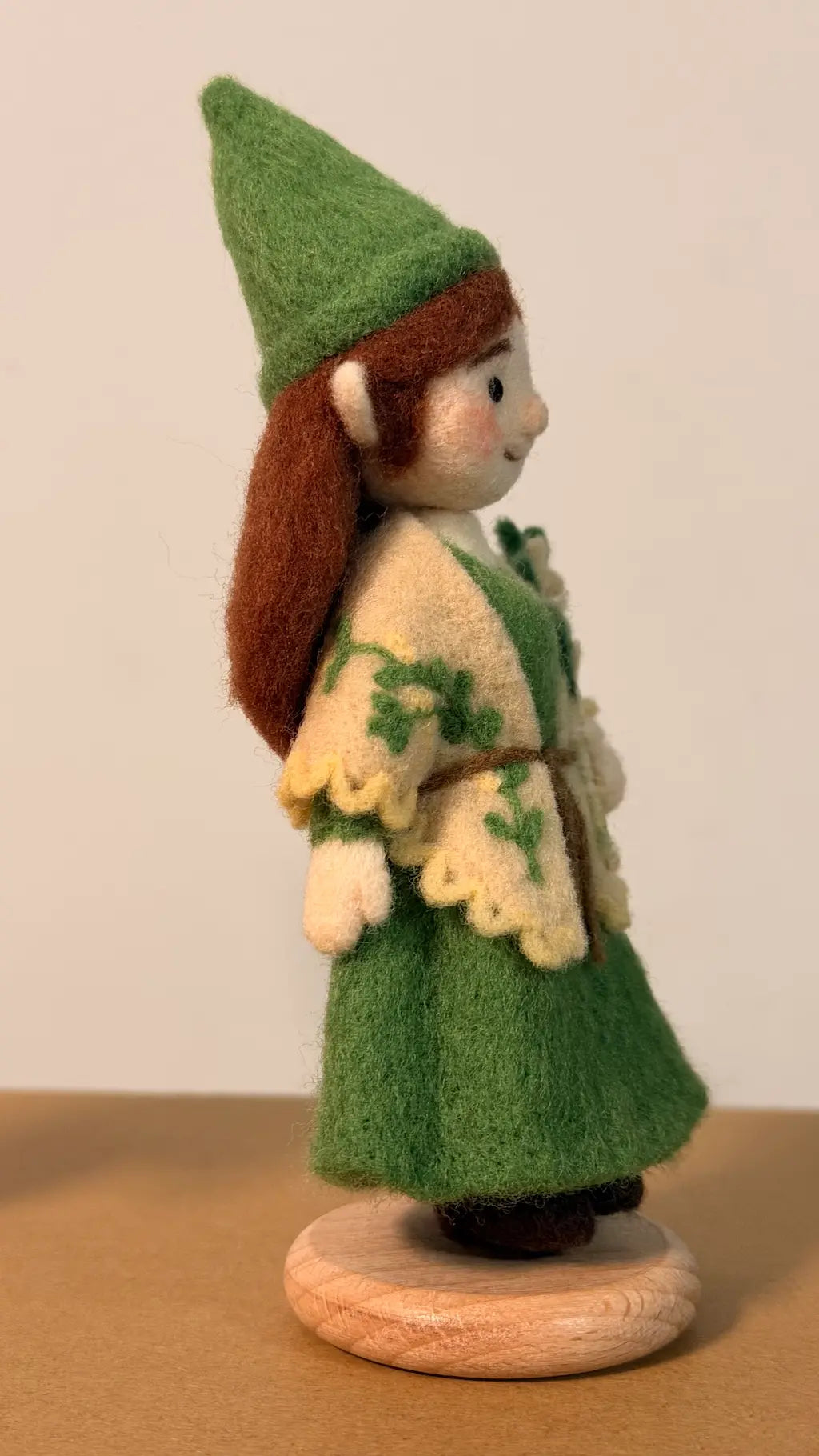 Felted elf figurine wearing a green outfit with a white background