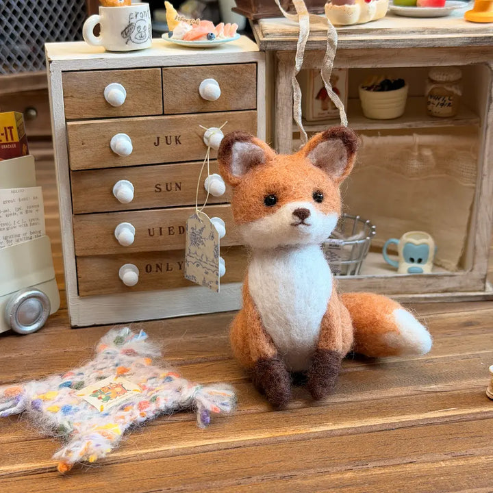 Red fox wool felt figurine displayed in a styled indoor setting