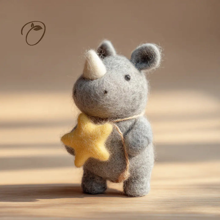 Three-quarter view of a gray felt rhino holding a yellow star, with a cream horn and beige neck cord.