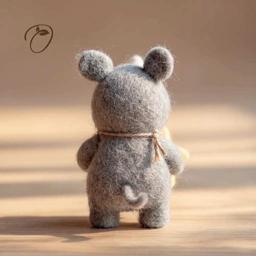 Back view of a gray felt rhino showing its small curled tail, rounded ears and cord tied at the neck.