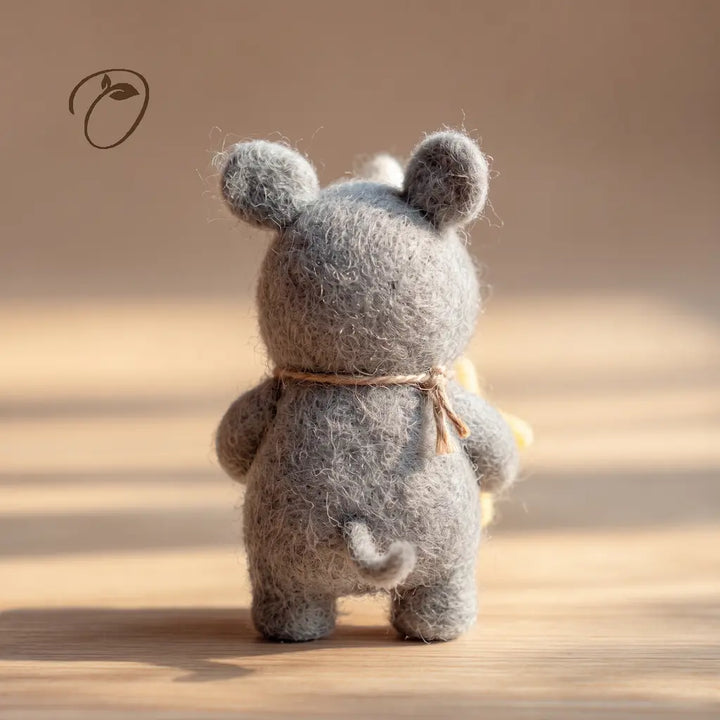 Back view of a gray felt rhino showing its small curled tail, rounded ears and cord tied at the neck.