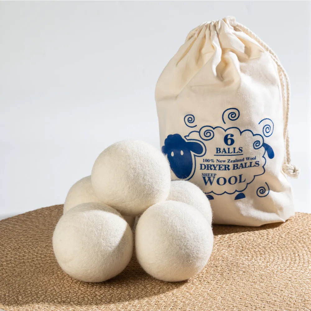Set of six natural white wool dryer balls nestled in a handmade cloth drawstring bag.