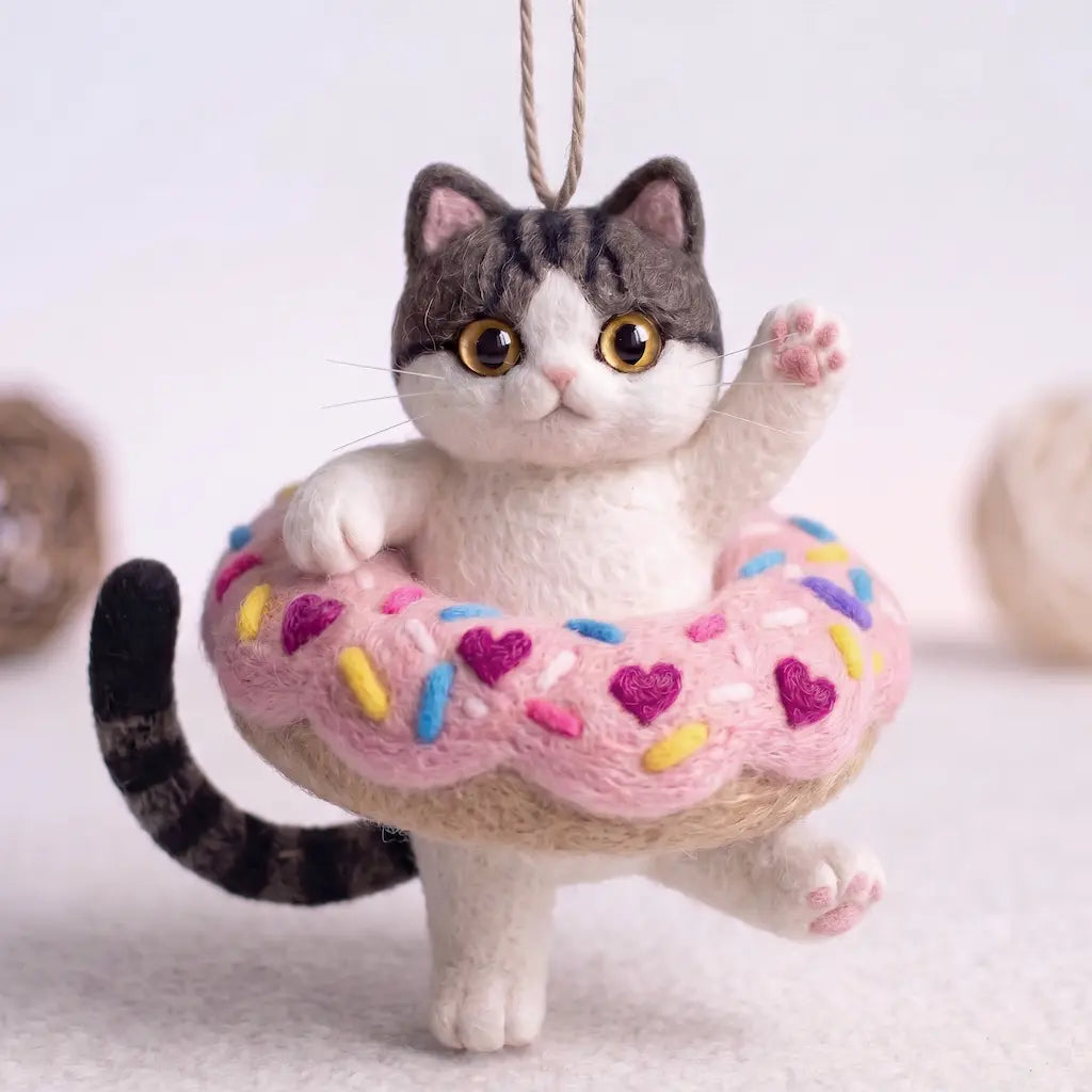 Donut Drifter Cat wool felt ornament in pink sprinkle donut with raised paw