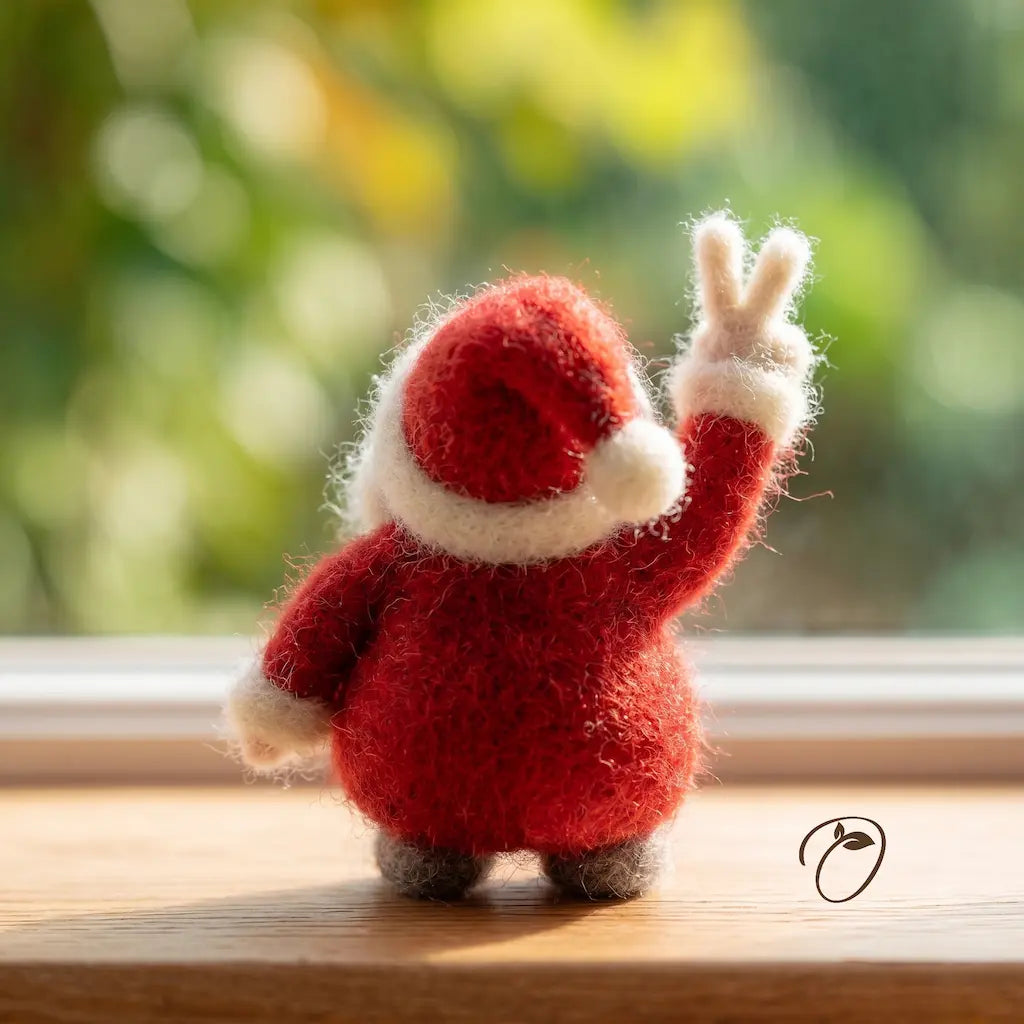 Small red plush toy waving on a wooden surface with a blurred green background