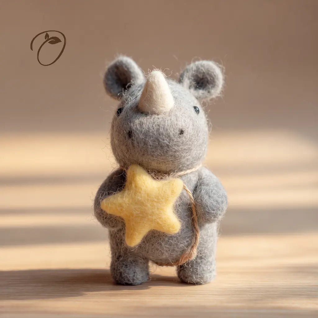 Front view of a gray felt rhino holding a yellow star against its chest, with an ivory-colored horn and rounded ears.