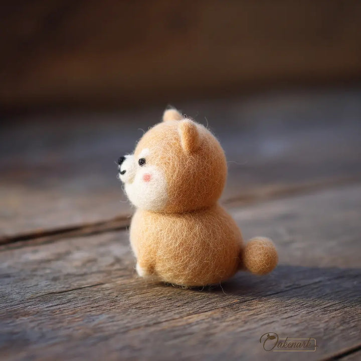 Small brown plush toy resembling a cat on a wooden surface