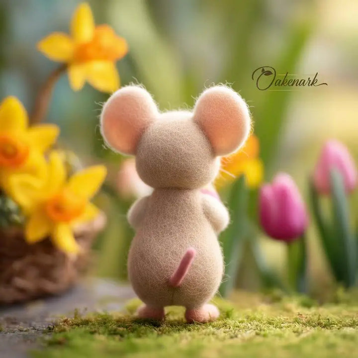 Small mouse figurine standing on grass with blurred flowers in the background