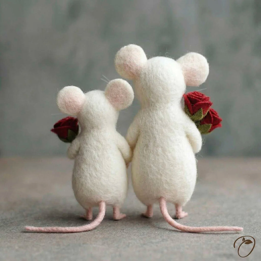 Two white mouse figurines holding red roses against a gray background