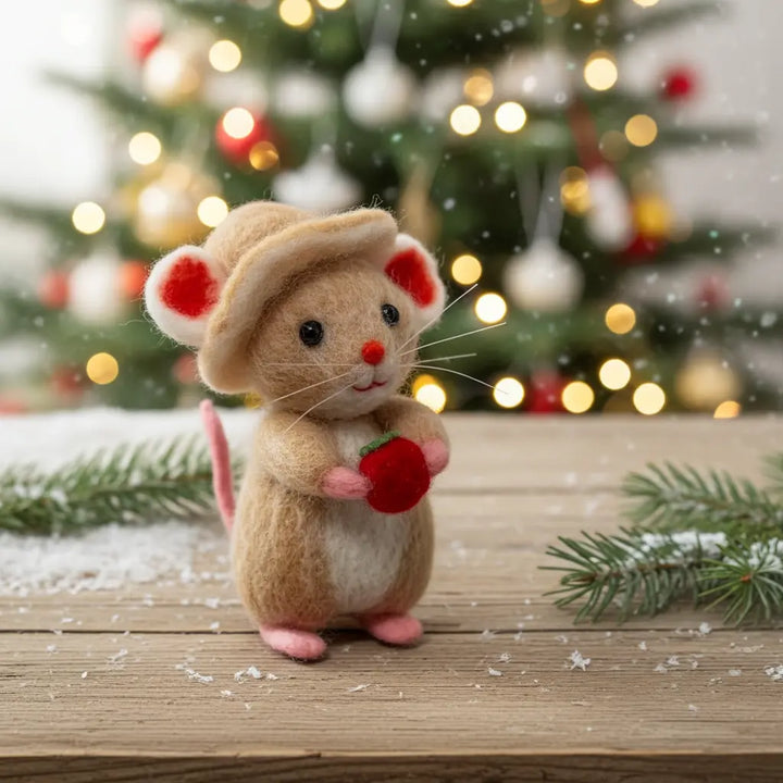 Plush mouse toy with a red apple in front of a Christmas tree