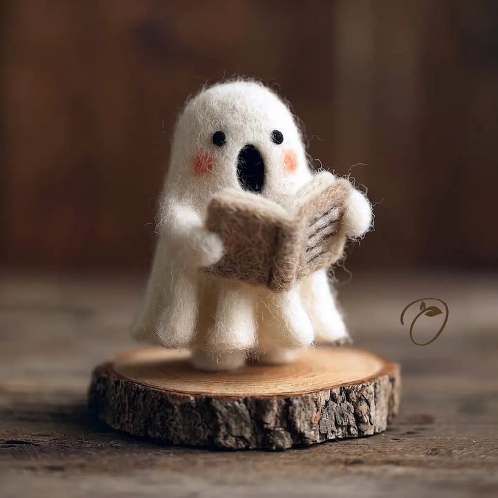 Front view of reading ghost felt figurine with rosy cheeks and open book