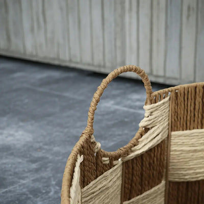 A close-up detail shot of the sturdy woven handle on the checkerboard basket