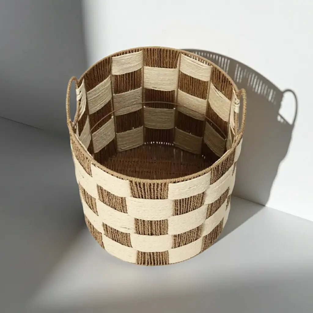 A round brown and cream checkerboard woven storage basket with handles