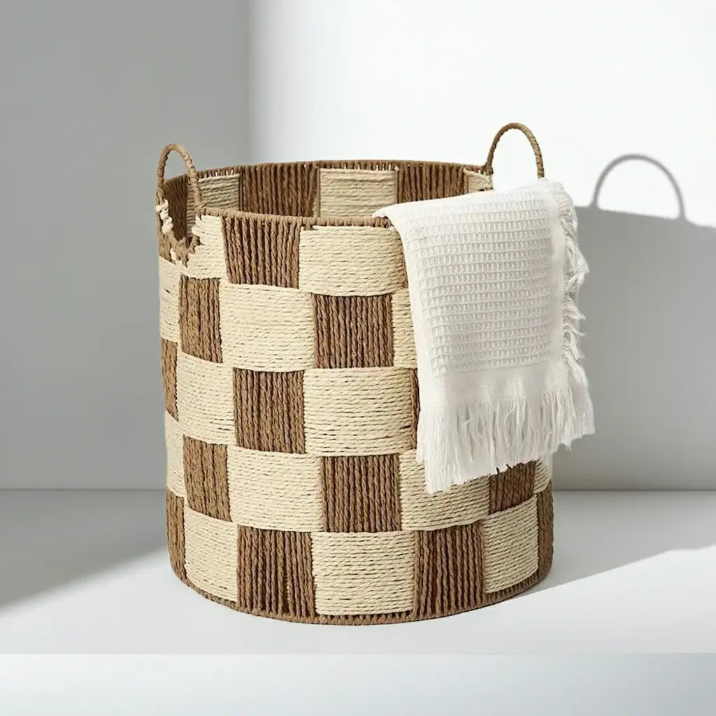 Checkerboard woven basket used as a stylish towel holder, perfect for a bathroom or laundry room