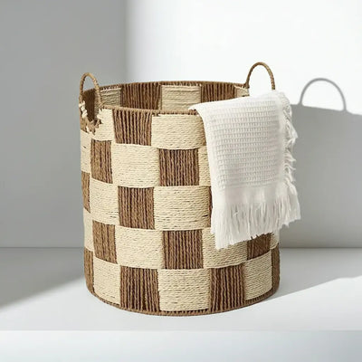 Checkerboard woven basket used as a stylish towel holder, perfect for a bathroom or laundry room