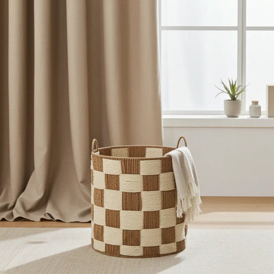 A round brown and cream checkerboard woven storage basket with handles