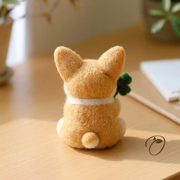 Back view of a golden tan felt corgi showing its cream neck marking and short tail with a cream tip