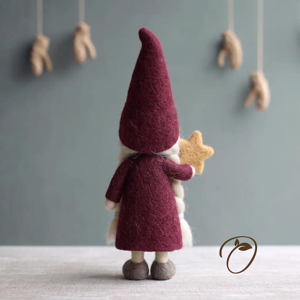 Back view of Nordic Mrs. Claus felt figurine with a burgundy pointed hat and dress, grey shoes, and a golden star.