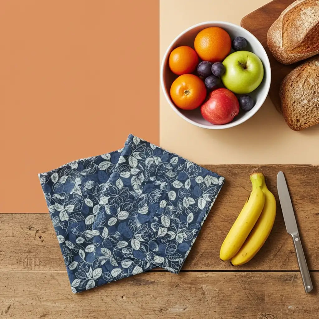 Round black bowl with cherry tomatoes and a floral-patterned lid on a white background