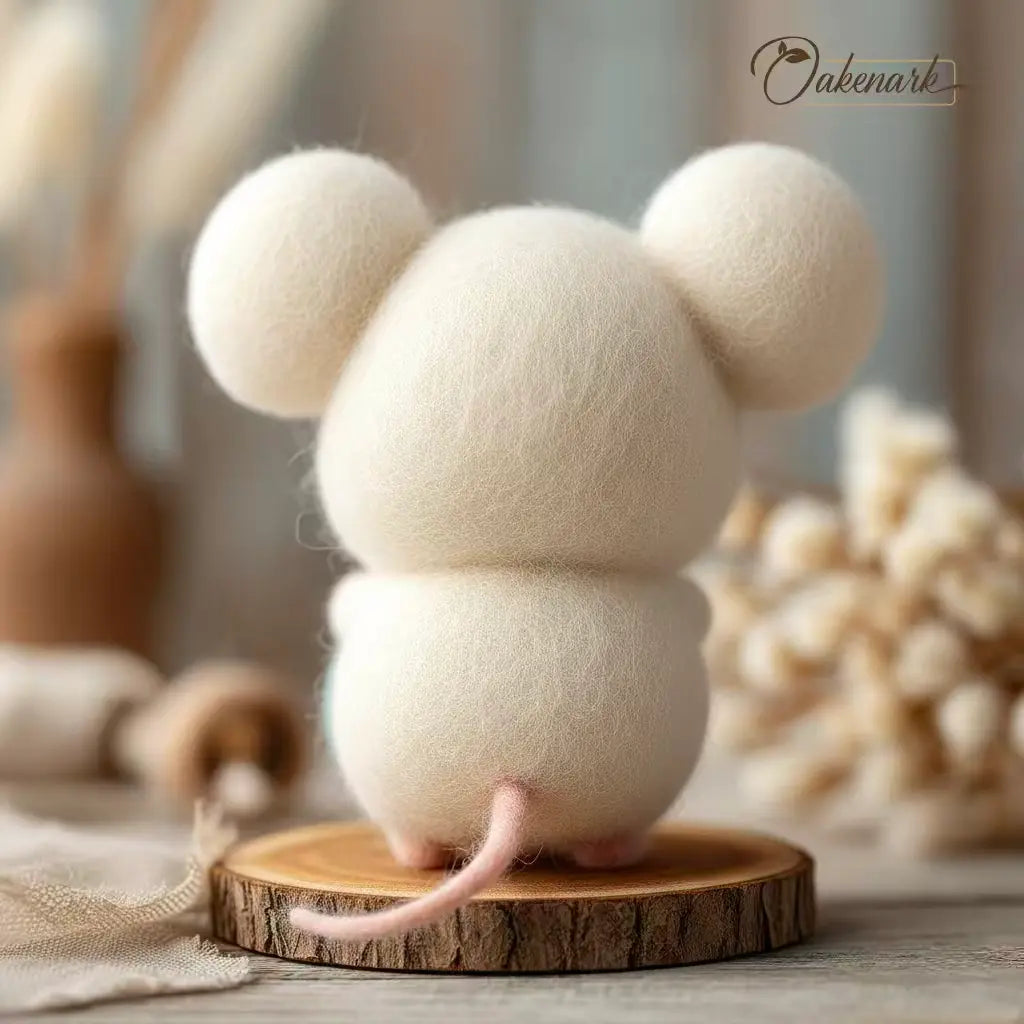 White woolen mouse on a wooden base with a blurred natural background
