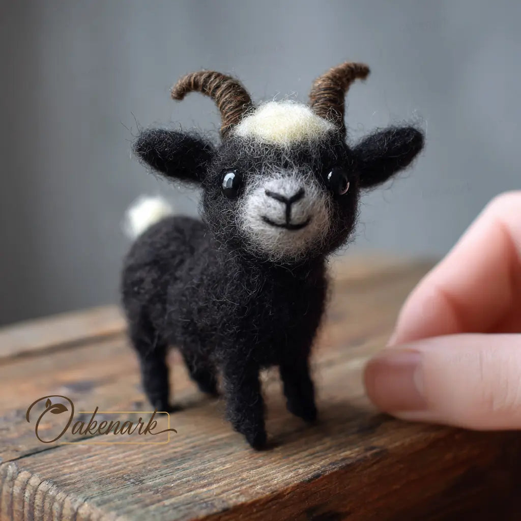 Small black goat figurine with a white patch on a wooden surface